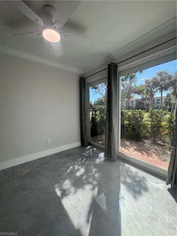Unfurnished room featuring ornamental molding, concrete floors, and ceiling fan