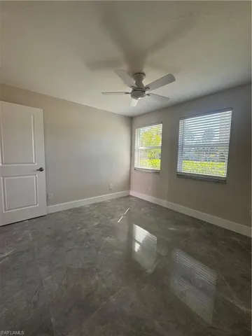 Spare room with baseboards and a ceiling fan