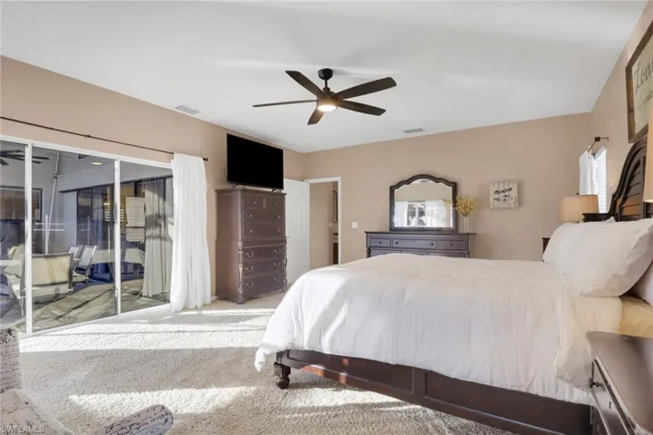 Carpeted bedroom featuring access to exterior and ceiling fan
