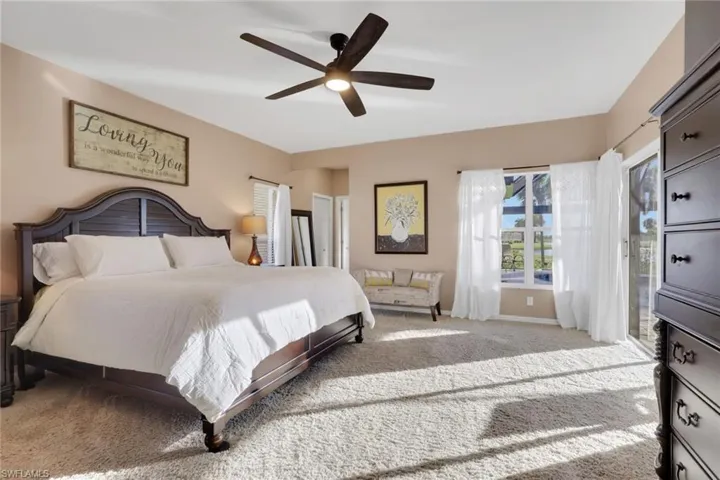 Bedroom featuring light colored carpet, a ceiling fan, and access to outside