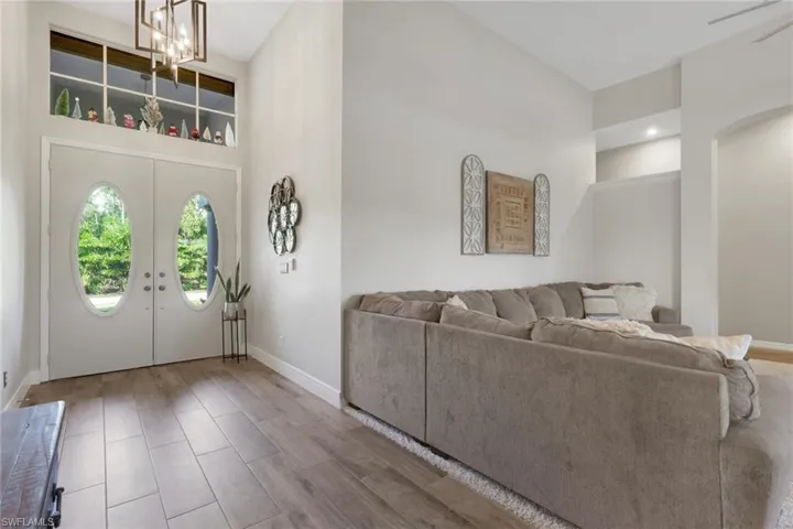 Entryway with a towering ceiling, french doors, wood tiled floors, and a chandelier
