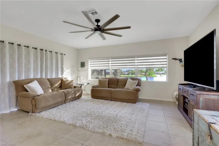 Living room with light tile patterned flooring and ceiling fan