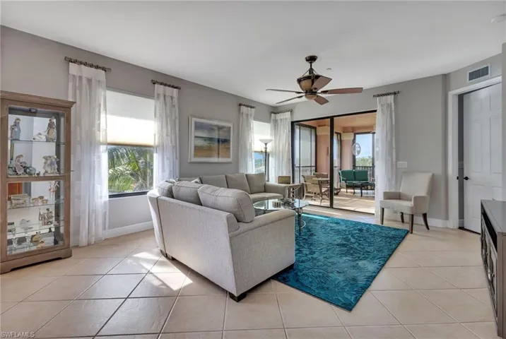 Tiled living room with a wealth of natural light and ceiling fan