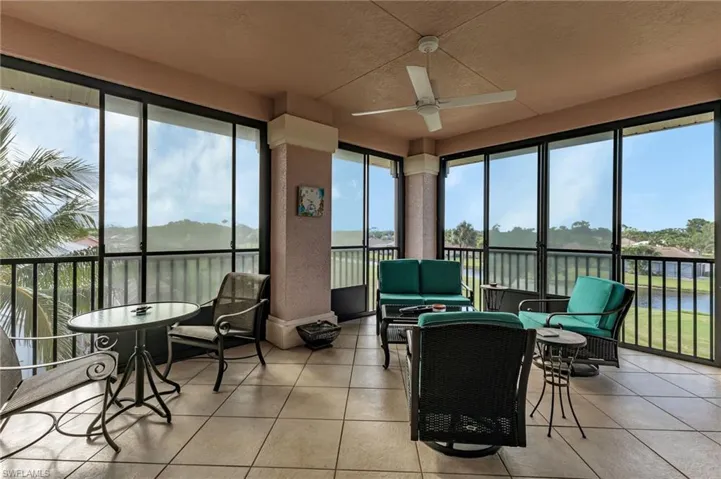 Sunroom / solarium featuring a water view, ceiling fan, and plenty of natural light