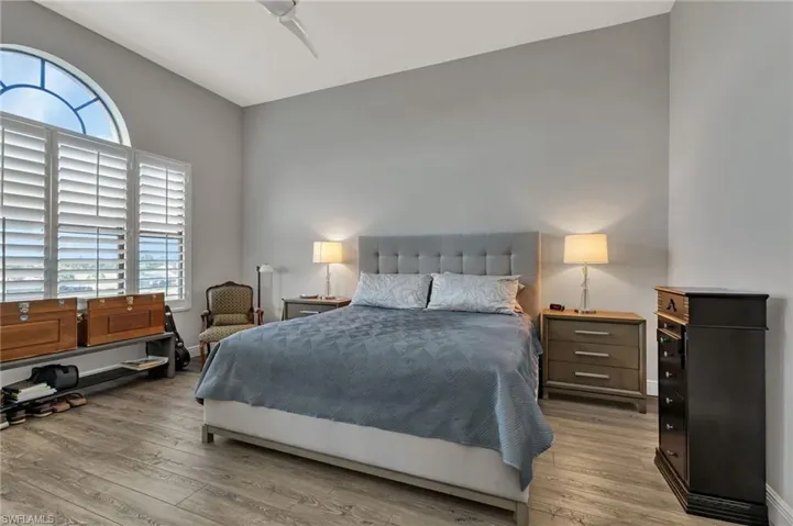 Bedroom with light hardwood / wood-style flooring, ceiling fan, and multiple windows