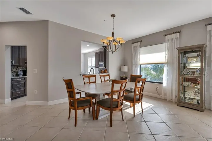 Dining space featuring a chandelier, light tile patterned floors, and a healthy amount of sunlight