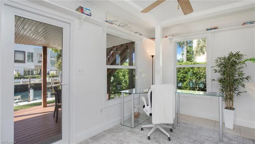 Tiled office featuring ceiling fan and plenty of natural light