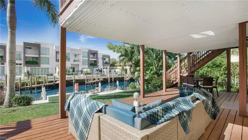 Wooden deck with a dock, an outdoor hangout area, and a water view