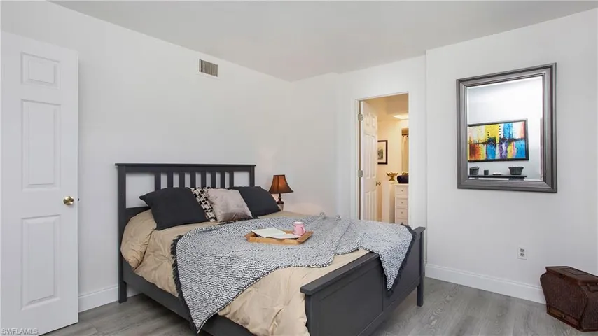 Bedroom with light wood-type flooring and ensuite bathroom