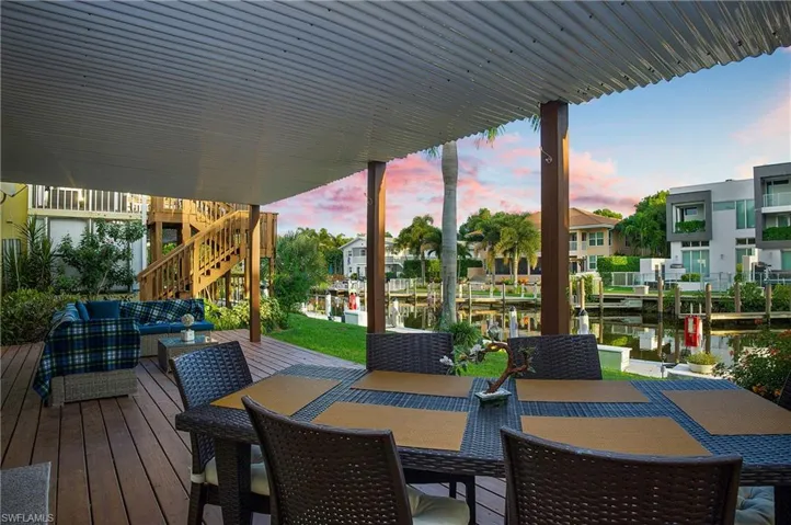 Deck at dusk with an outdoor hangout area, a water view, and a dock