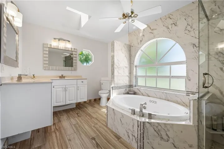 Primary bathroom with double sink vanity, separate walk in shower and soaking tub