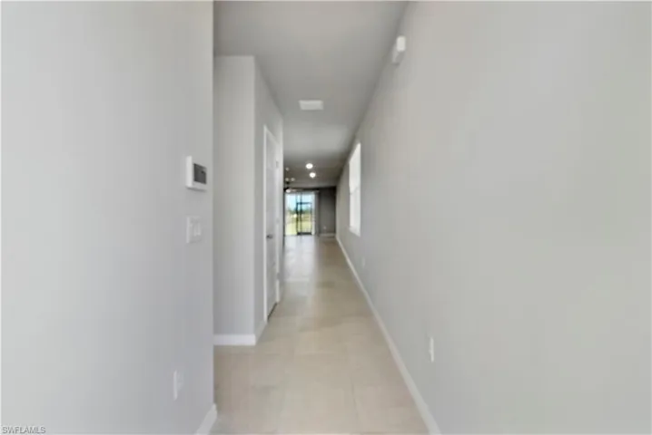 Hallway featuring light tile floors
