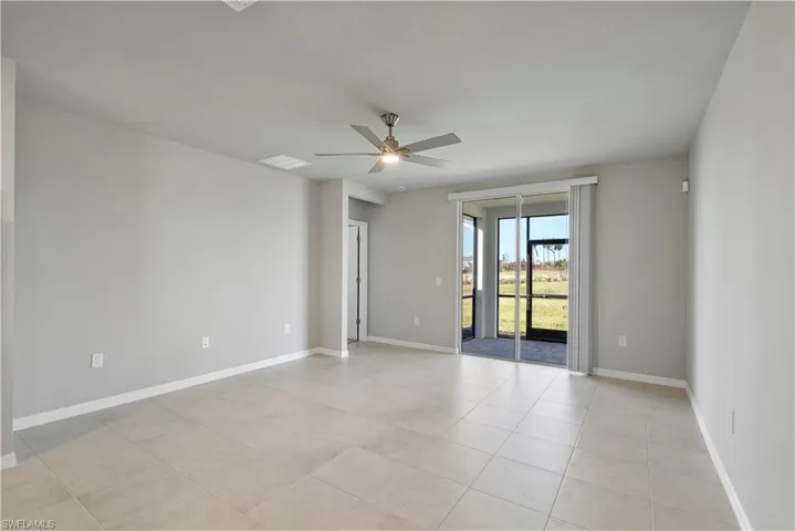 Unfurnished room with ceiling fan and light tile floors