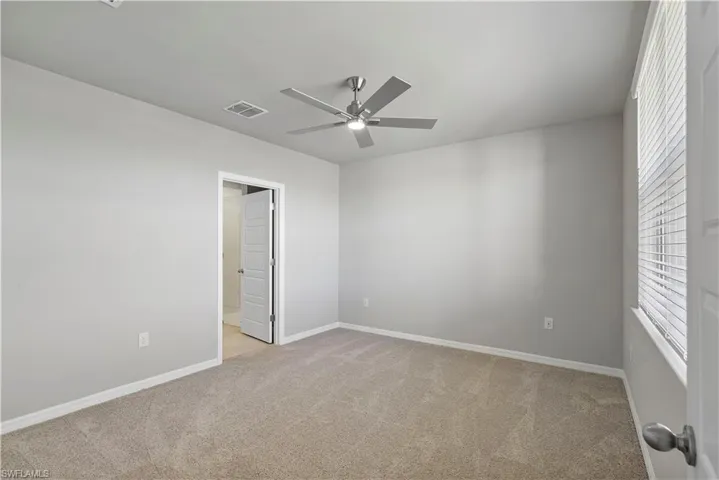 Spare room with ceiling fan and light colored carpet