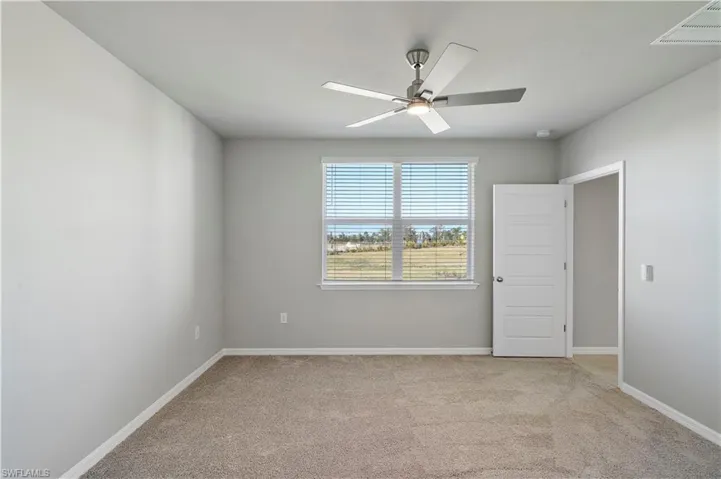 Carpeted spare room with ceiling fan