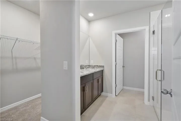 Bathroom featuring an enclosed shower, tile flooring, and large vanity