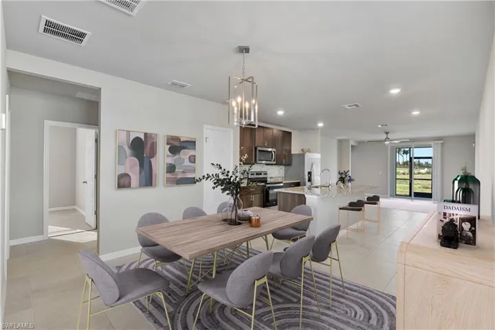 Dining area featuring ceiling fan with notable chandelier, light tile patterned flooring, and sink