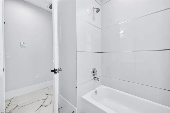Full bathroom with  shower combination and marble finish flooring
