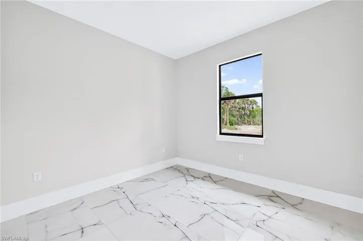 Empty room featuring baseboards and marble finish floors