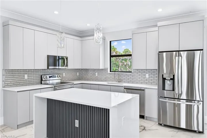 Kitchen with light marble finish flooring, stainless steel appliances, tasteful backsplash, modern cabinets, and light stone countertops