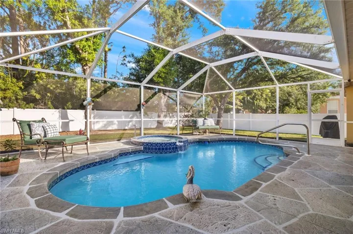 View of swimming pool featuring a lanai, an in ground hot tub, and a patio