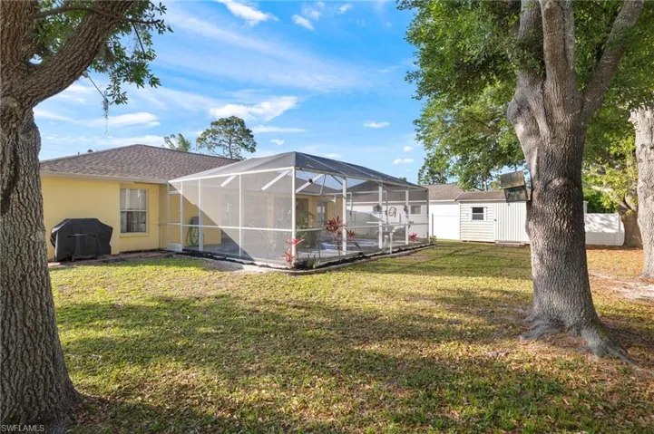 View of yard featuring a lanai and a storage unit