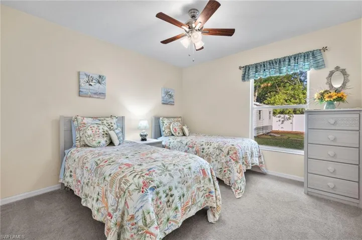 Bedroom with ceiling fan and light carpet