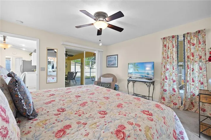 Carpeted bedroom with access to exterior and ceiling fan