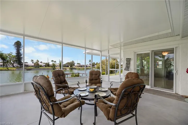 Enclosed patio featuring a solid roof, screen walls, light-colored flooring, and sliding glass door access
