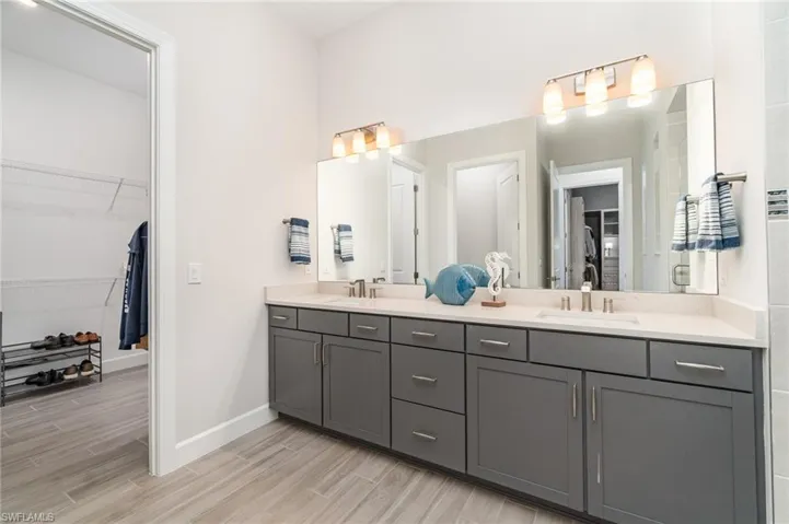 Double bowl vanity with access to secondary walk-in closet.