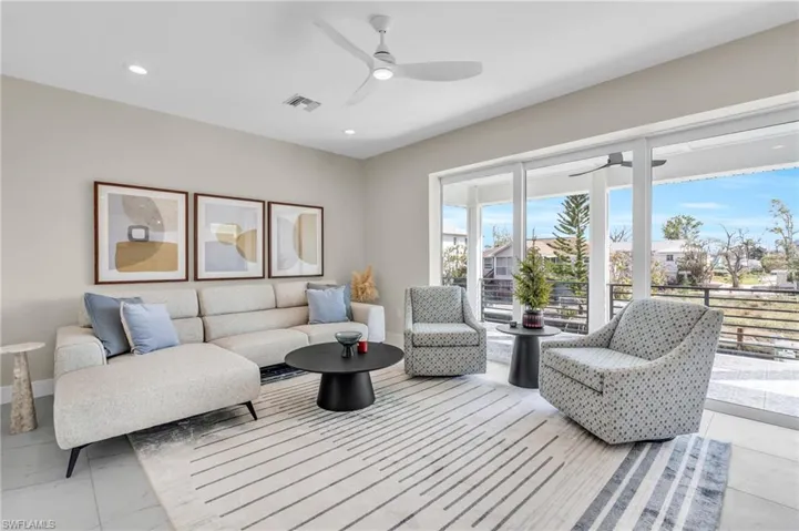 Living room featuring ceiling fan /  virtually enhanced photo