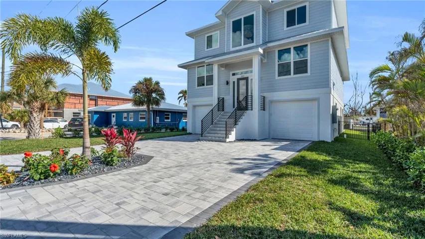 View of front of property featuring a garage and a front lawn VIRTUALLY ENHANCED