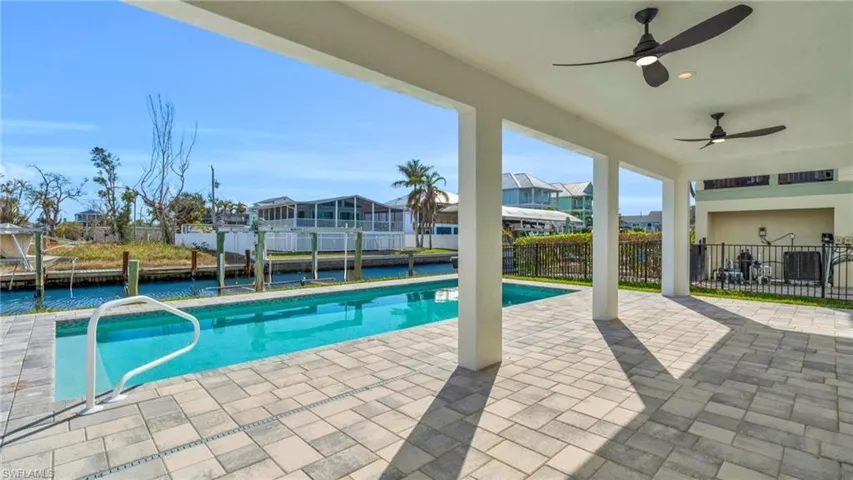 VIRTUALLY ENHANCED - View of pool with a dock, ceiling fan, and a patio area