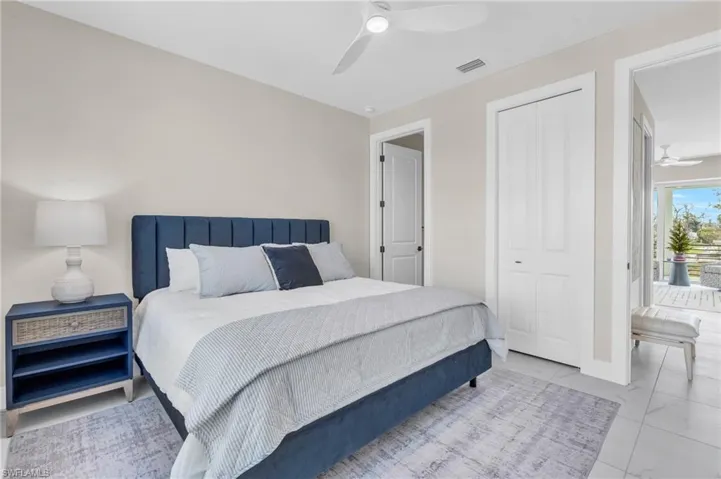 Bedroom with a closet and ceiling fan /  virtually enhanced photo