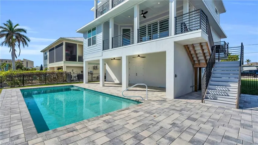 Back of house featuring ceiling fan, a fenced in pool, a balcony, and a patio VIRTUALLY ENHANCED
