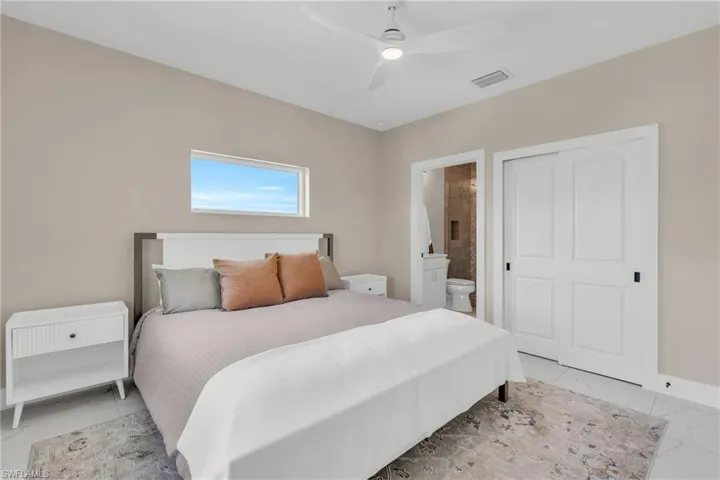 Bedroom with ceiling fan and ensuite bath
