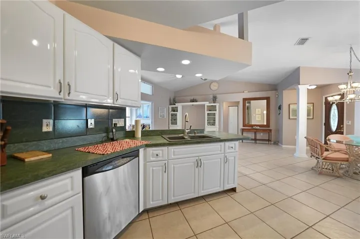 Kitchen with sink, backsplash, white cabinets, and dishwasher