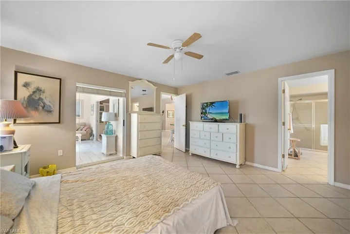 Bedroom featuring ceiling fan, connected bathroom, and light tile patterned floors