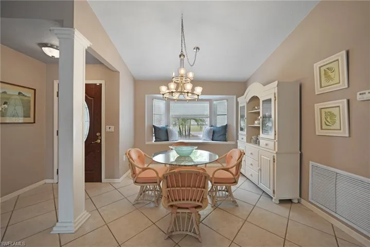 Tiled dining area with decorative columns and an inviting chandelier