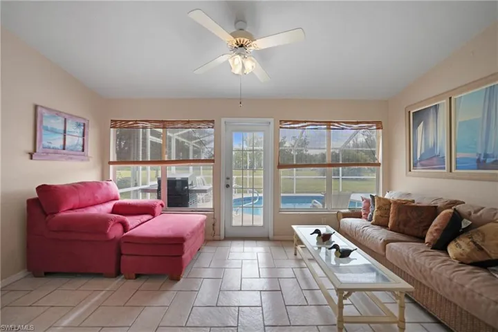 Florida room opens to pool area, featuring ceiling fan and plenty of natural light