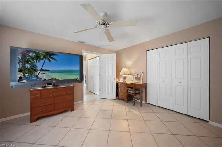 Bedroom 2 featuring ceiling fan, light tile patterned floors, and a closet