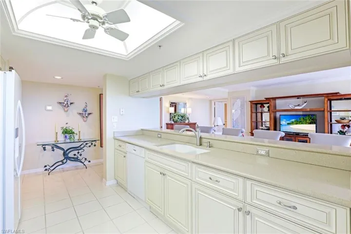 Kitchen with white appliances, a ceiling fan, open floor plan, light tile patterned floors, and recessed lighting