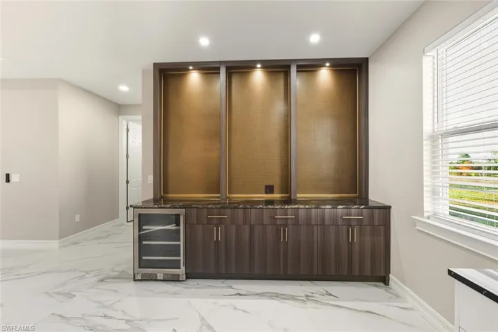 Detailed view of beverage cooler, recessed lighting, and a bar