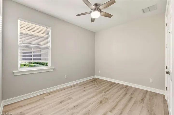 Unfurnished room with light wood finished floors, plenty of natural light, and ceiling fan
