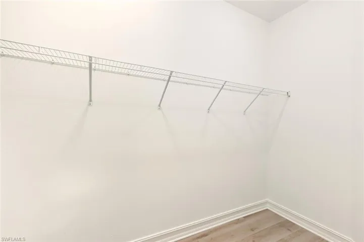 Walk in closet with light wood finished floors