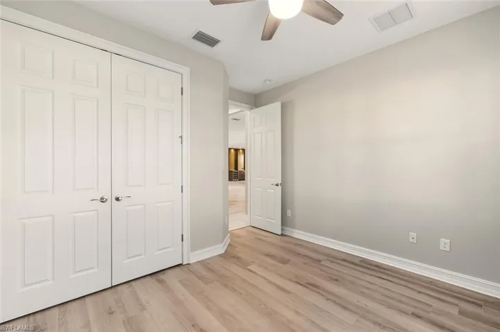 Unfurnished bedroom with a closet, light wood-style floors, and a ceiling fan