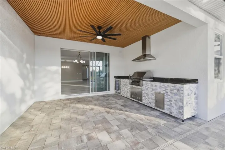 View of patio / terrace with an outdoor kitchen, ceiling fan, and wine cooler
