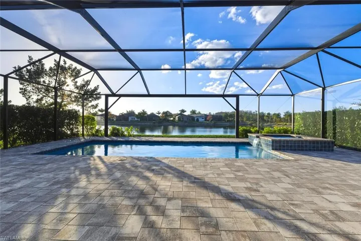 Integrated pool / hot tub featuring a sunroom, a patio, glass enclosure, a water view, and a residential view