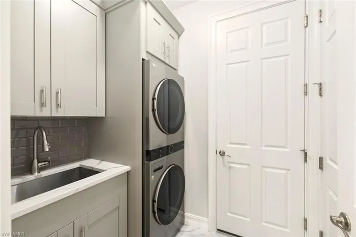 Laundry area with stacked washer and clothes dryer and cabinet space
