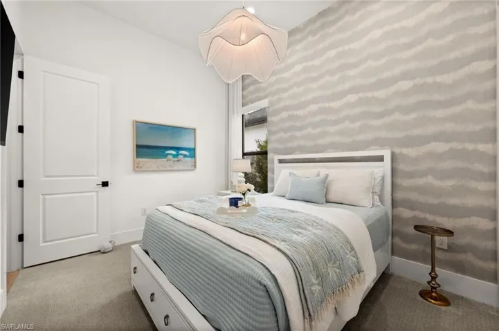 Bedroom with an accent wall, carpet floors, and wallpapered walls